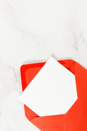 Top view of red envelope, white card on white marble background. Post flat lay. Copy space.の写真素材