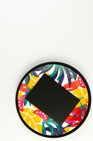 Top view of black tray, colorful plate, black card on white background. Exotic plant plate, summer...