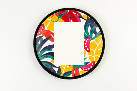 Top view of black tray, colorful plate, white card on white background. Exotic plant plate, summer...