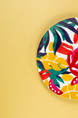 Top view of colorful plate on yellow background. Exotic plant plate, summer picnic. Flat lay, copy space.の写真素材