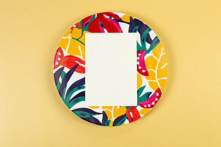 Top view of colorful plate, white card on yellow background. Exotic plant plate, summer picnic. Flat lay, copy space.の写真素材