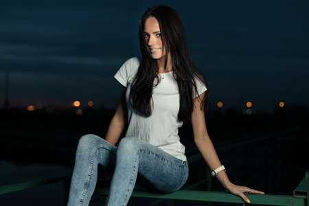 Young beautiful girl outdoors at nightの写真素材