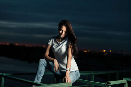 Young beautiful girl outdoors at nightの写真素材