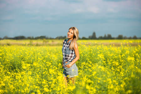 Lovely blonde woman in bright yellow fieldの写真素材