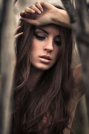 Beautiful young topless woman posing outdoors. Dark mysterious artistic portrait.の写真素材