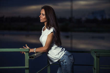 Young beautiful girl outdoors at nightの写真素材