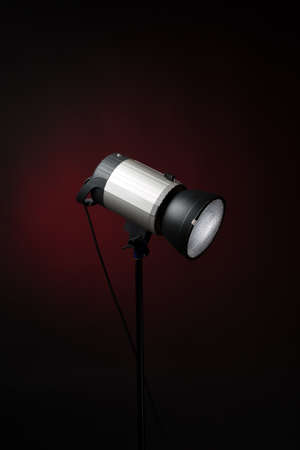 Studio strobe on dark background. Professional lighting equipment. Reflector with honeycomb.の写真素材
