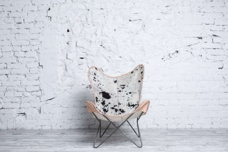 Stylish modern chair with animal print against white brick wall. Loft interior conceptの写真素材