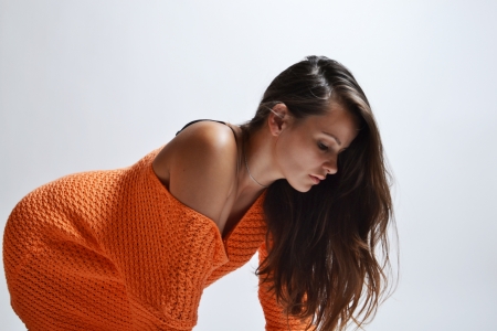 beautiful woman wearing orange sweater, studio shotの写真素材