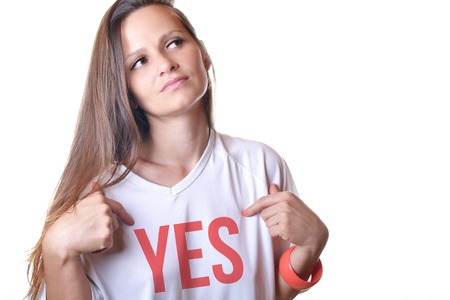  A beautiful young woman pointing at word on her white t-shirt, isolated on a white background