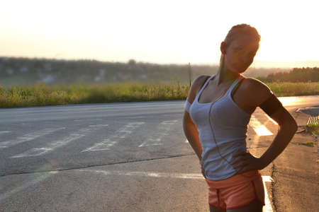 young woman working out in the park at sunset or sunrise
