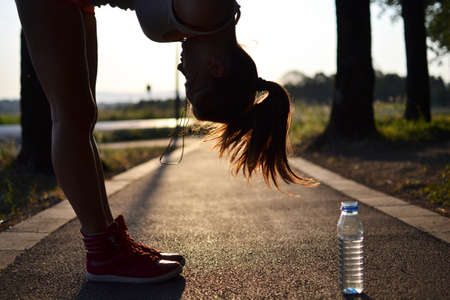 young woman working out in the park at sunset or sunriseの写真素材