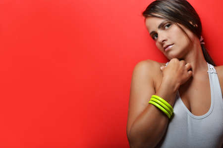 beautiful young woman posing against red background