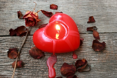 Red heart shaped candle on wooden backgroundの写真素材