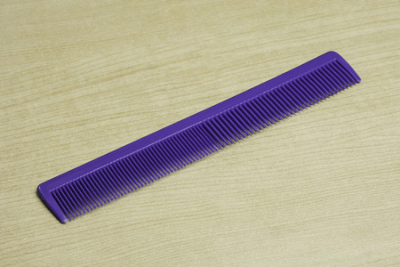plastic hair comb on wood table