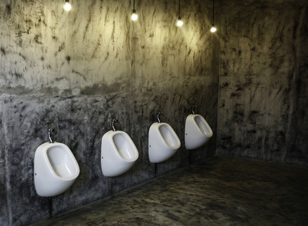 Line of white porcelain urinals in public toiletsの写真素材
