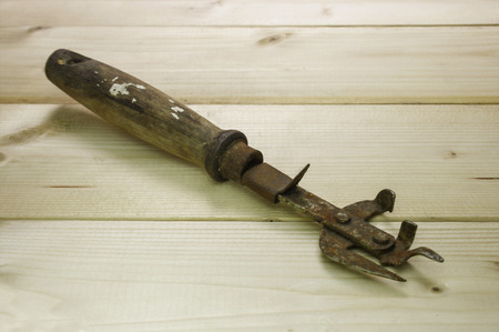 Old dirty, rusty can opener with wood handleの写真素材
