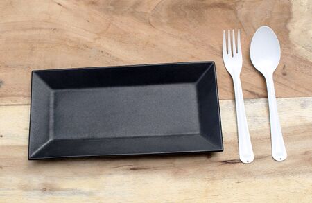 empty plate with spoon and fork ,top view. on wood background
