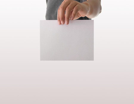 Advertising: Hand holding white empty paperの写真素材