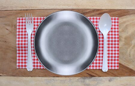 plate on tablecloth and spoon with fork for food serving backgroundの写真素材