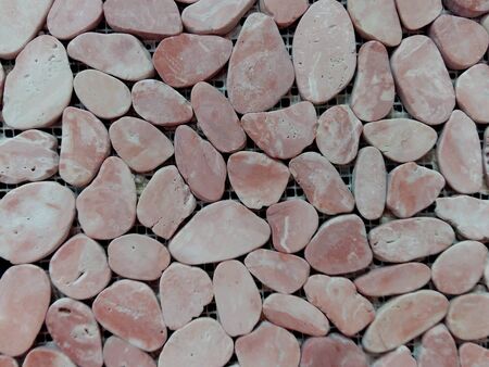gray sea pebble stone wall texture backgroundの写真素材