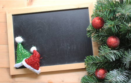 christmas tree with decorations ball on and blackboard on wooden backgroundの写真素材