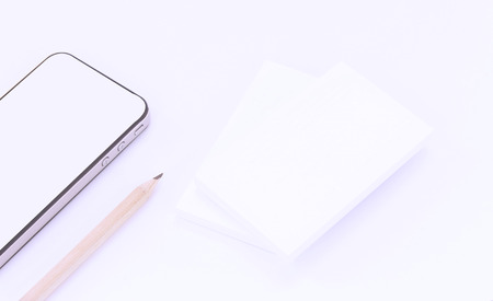 Mockup of business cards with smart phone on white textured paper backgroundの写真素材