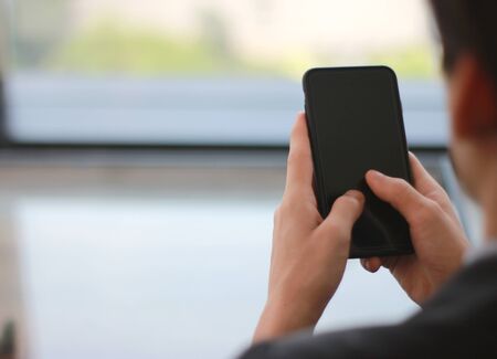 Mock up of a business man holding smartphone device の写真素材