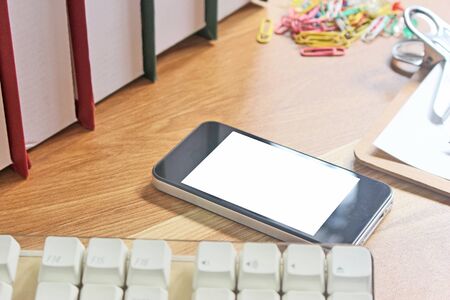 Workspace with mobile phone and office equipments on wood desk work background