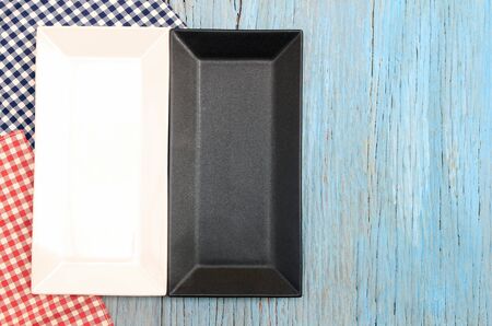 black and white plate on tablecloth on wood table background