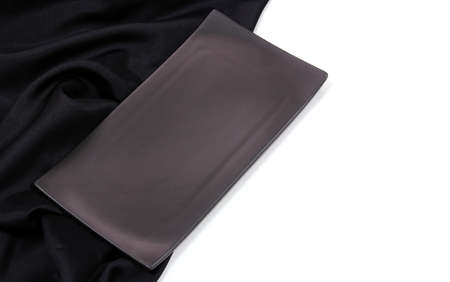 Empty black rectangle modern ceramic plate with silk tablecloth texture on white background , Top...
