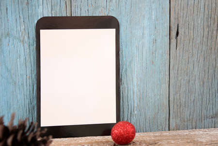 Tablet and Christmas ball decor on wooden backgroundの写真素材