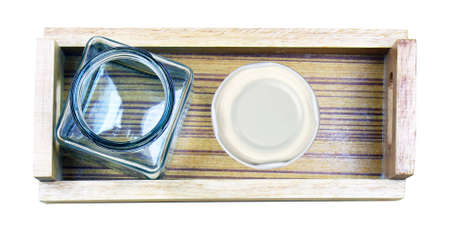 glass bottle on wooden tray isolated on white backgroundの写真素材