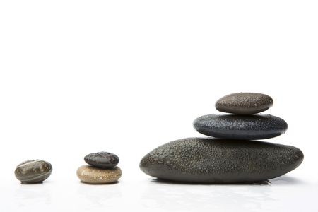 Group of black stones with the water drops, lying on a white background