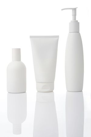 Three white cosmetic bottles stand on a white backgroundの写真素材