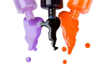 The colour nail polish which is pouring out from bottles on a white backgroundの写真素材