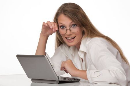 The modern, beautiful, young woman sits at a table with a personal computerの写真素材