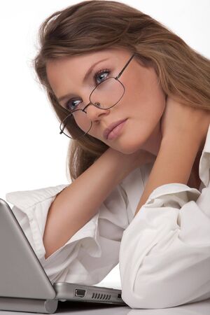 The modern, beautiful, young woman sits at a table with a personal computerの写真素材