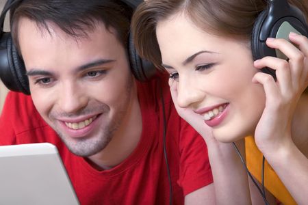 The young man and the girl communicate, having control over musical ear-phonesの写真素材