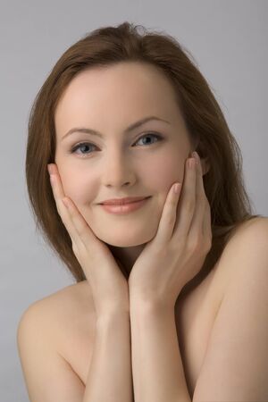 Portrait of young beautiful girl with naked shoulders, covered hands.の写真素材