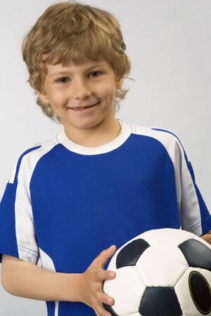 The young football player with  ball in handsの写真素材
