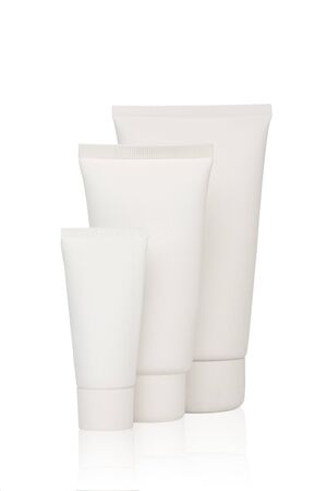 Three white cosmetic bottles stand on a white backgroundの写真素材