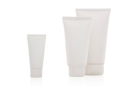 Three white cosmetic bottles stand on a white backgroundの写真素材