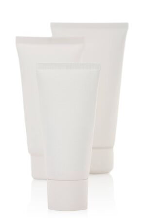 Three white cosmetic bottles stand on a white backgroundの写真素材