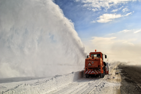 Snow-covered road cleaning by snow removal machine.の写真素材