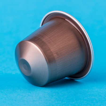 Brown bronze coffee cup on a blue background. Modern conceptual art.の写真素材