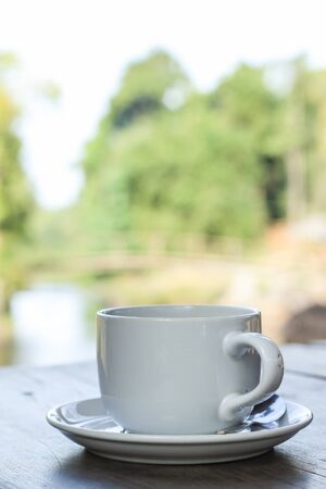 White cup of coffe near  riverの写真素材