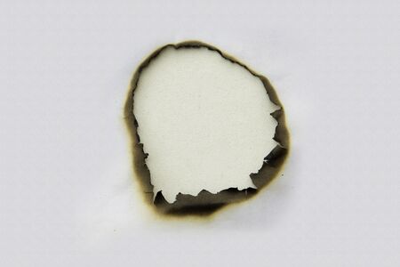 Fire holes in white paperの写真素材