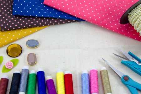 Tools for sewing and handmade  thread, scissors, pins on brown paper 