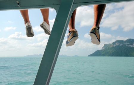 Couple traveler hanging leg sitting relaxed on the boat during the trip.